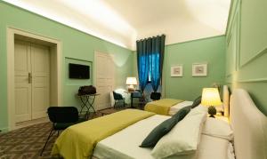ミラッツォにあるI PRINCIPI di CASADOR HOUSE HOTELの緑の壁のベッドルーム1室(ベッド2台付)