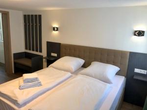 una camera da letto con due letti con asciugamani sopra di City Apartments, Outlet 100 Meter a Metzingen