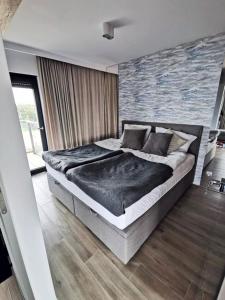 a bedroom with a large bed in a room at Apart House by Gardenia in Dziwnów