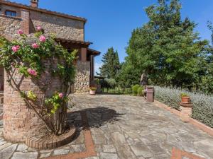 a stone walkway in front of a building with flowers at Tranquil Holiday Home in Volterra with Swimming Pool in Volterra
