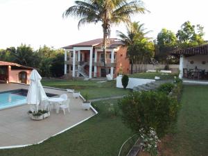 uma casa com um quintal com uma piscina e uma casa em Pousada Doce Vida Guarapari em Guarapari