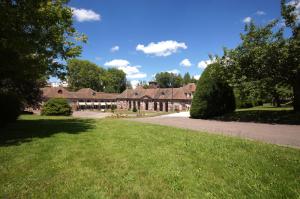 a large house with a green lawn in front of it at F2 Aux pieds des Thermes 3 étoiles in Luxeuil-les-Bains