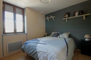 1 dormitorio con cama y ventana en F2 Aux pieds des Thermes 3 étoiles en Luxeuil-les-Bains