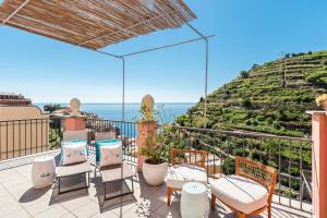 a patio with chairs and a view of the ocean at La Torretta Lodge in Manarola
