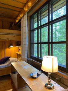 uma lâmpada sobre uma mesa num quarto com janelas em Arctic Lodges Lapland Ski in, slopes, ski tracks, National Park, free Wi-Fi - Lapland Villas em Pyhätunturi