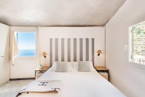 - une chambre avec un grand lit blanc et 2 fenêtres dans l'établissement La Torretta Lodge, à Manarola