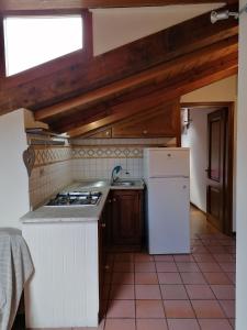 een keuken met een fornuis en een witte koelkast bij Theatrum in Aosta