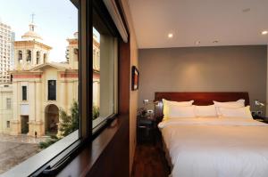 a bedroom with a bed and a large window at Windsor Hotel in Córdoba