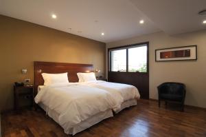 a bedroom with a large white bed with a window at Windsor Hotel in Córdoba