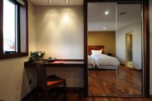 a bedroom with a bed and a desk and a mirror at Windsor Hotel in Córdoba