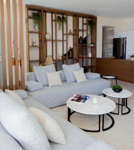 a living room with two couches and two tables at Made of Blue luxury suites collection in Rethymno +88 photos