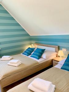 sypialnia z 2 łóżkami i białymi i niebieskimi poduszkami w obiekcie Zagaje Pokoje Gościnne w Sarbinowie