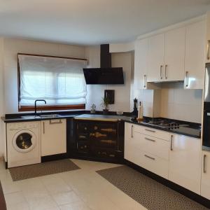 - une cuisine avec des placards blancs et un lave-linge/sèche-linge dans l'établissement Casa Tita apartamento, à Villalonga