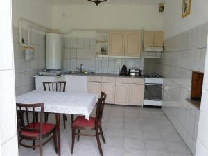 y cocina con mesa, sillas y fogones. en Mi-Ri Balance vendégház, en Szinpetri