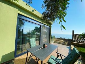 a table and chairs on a patio with a view of the ocean at Private Sea view house Belonika in Benitses