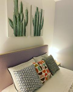 a bedroom with a bed with two cactus paintings on the wall at Private Sea view house Belonika in Benitses