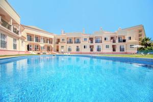 a large swimming pool in front of a building at Aquamar Albufeira Aparthotel in Albufeira