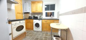a small kitchen with a washer and dryer in it at Grace Apartments - Living Waters 2 in Ashford