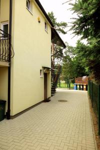 a walkway next to a building with a staircase at Apartament z tarasem i ogrodem in Dziwnówek