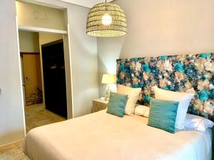 a bedroom with a large bed with a floral headboard at Hotel Spa Adealba in Mérida