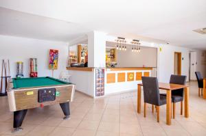 a living room with a pool table and a kitchen at Aquamar Albufeira Aparthotel in Albufeira