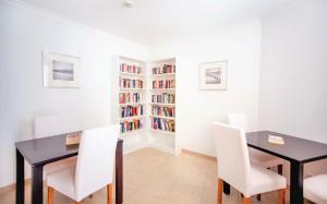 a dining room with a black table and white chairs at Aquamar Albufeira Aparthotel in Albufeira