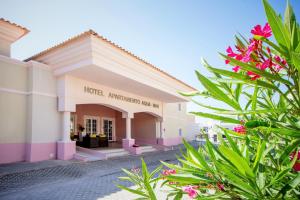 a hotel entrance with flowers in the foreground at Aquamar Albufeira Aparthotel in Albufeira