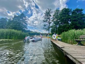 a group of people on boats in the water near a dock at Domek z basenem na Mazurach in Giże