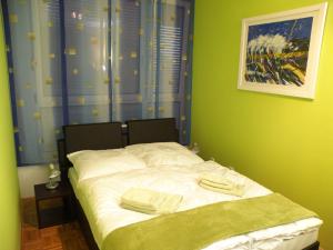 uma pequena cama num quarto com paredes verdes em Prestige Apartman Zagreb em Zagreb