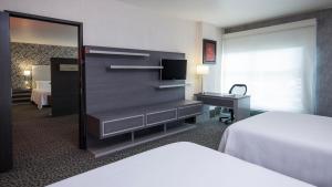 um quarto com uma cama e uma cómoda com um espelho em Holiday Inn Express & Suites Queretaro, an IHG Hotel em Querétaro