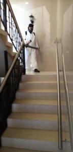 Een man in een afstudeer uniform die de trap af loopt. bij Hotel Español Neiva in Neiva