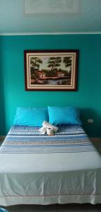 a bed with a stuffed animal sitting on top of it at Hotel Español Neiva in Neiva