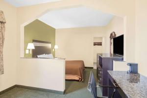 Habitación de hotel con cama y espejo en Howard Johnson by Wyndham North Bergen en North Bergen