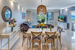 a dining room and living room with a table and chairs at Poinciana Lodge - 2 bedroom - on Hamilton Island by HIHA in Hamilton Island