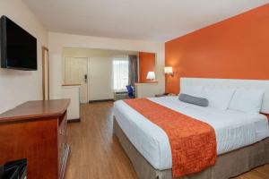 a hotel room with a large bed and a flat screen tv at Howard Johnson by Wyndham Savannah GA in Savannah