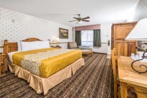 a hotel room with a bed and a couch at Days Inn by Wyndham Lebec in Grapevine