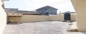 an empty courtyard of a house with a building at Brannic Lodge in Accra