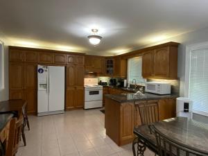 a kitchen with wooden cabinets and a white refrigerator at Leslie in Wasaga Beach