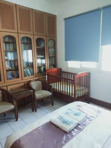 a bedroom with a bed and two chairs and cabinets at Frank B&B in Jincheng