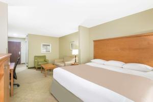 Habitación de hotel con cama grande y escritorio. en Super 8 by Wyndham Savannah, en Savannah