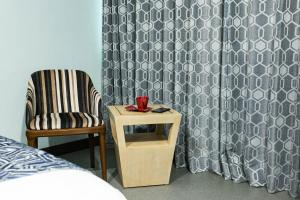 a bedroom with a bed and a chair and a table at Bay Area Suites Manila in Manila