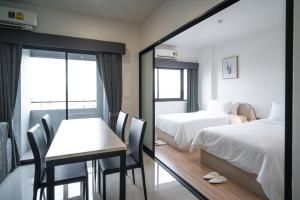 a hotel room with a table and a bed and a mirror at KOS Hotel Suvarnabhumi Airport -SHA Extra Plus in Min Buri +40 photos