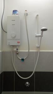 una manguera conectada a una ducha en el baño en Homestay 2007 Pangsapuri Ladang Tok Pelam Kuala Terengganu, en Kuala Terengganu
