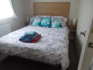 a bedroom with a bed with a white comforter at ty gwyn in Abergele