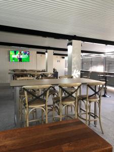 a dining room with tables and chairs and a tv at Club Hotel Motel Roma in Roma