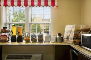 a kitchen with a counter with a window and a counter top at Microtel Inn & Suites by Wyndham Columbia Fort Jackson N in Columbia