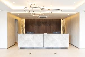 an office lobby with a reception desk and a chandelier at KOS Hotel Suvarnabhumi Airport -SHA Extra Plus in Min Buri