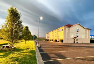 an empty parking lot next to a building with a street light at Baymont by Wyndham Paw Paw in Paw Paw