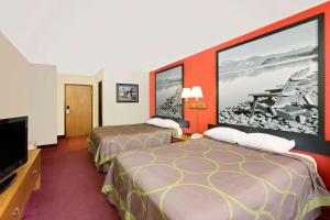 a hotel room with two beds and a flat screen tv at Super 8 by Wyndham Mound City in Mound City