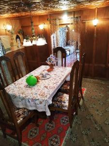 - une salle à manger avec une table et un bol vert dans l'établissement Houseboat Young Snow View Front Line Dal Lake, à Srinagar